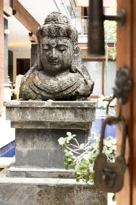 a statue of a head on a ledge with a plant at Winy Estate - Luxury Villa with Rooftop Jacuzzi in Canggu