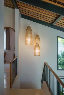 two pendant lights hanging from a wall with a staircase at Casa Donilo - 4BR Designer Villa in Canggu in Canggu