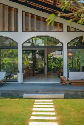 a house with large windows and a lawn at Casa Donilo - 4BR Designer Villa in Canggu in Canggu