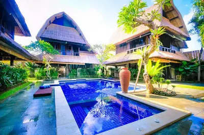a villa with a swimming pool in front of a house at Radiant Jepun Villa in Legian
