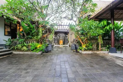 a courtyard of a building with trees and plants at Radiant Jepun Villa in Legian