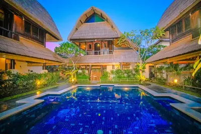 a villa with a swimming pool in front of a house at Radiant Jepun Villa in Legian