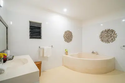 a bathroom with a large tub and a sink at Sari Temuku Villa in Seminyak