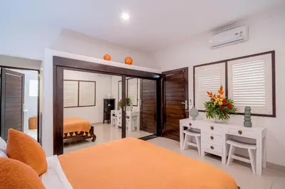 a bedroom with a bed and a desk with flowers on it at Sari Temuku Villa in Seminyak