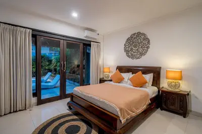 a bedroom with a bed and a large window at Sari Temuku Villa in Seminyak