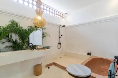 a bathroom with a bath tub and a table at Villa Jodoh - Exciting Chic 4BR Stylish Villa Near Seminyak, Perfect for a Trendy Getaway in Kerobokan