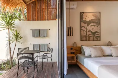 a bedroom with a bed and a table and chairs at Villa Jodoh - Exciting Chic 4BR Stylish Villa Near Seminyak, Perfect for a Trendy Getaway in Kerobokan