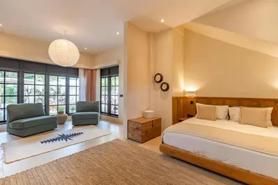 a bedroom with a bed and a couch and a chair at Villa Jodoh - Exciting Chic 4BR Stylish Villa Near Seminyak, Perfect for a Trendy Getaway in Kerobokan