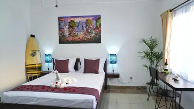 a bedroom with a bed with a stuffed animal on it at Balian Surf Club in Legian