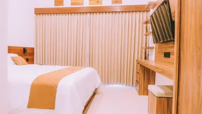 a hotel room with a bed and a television at Budha Manis Villa in Kerobokan