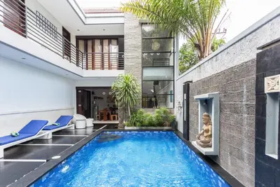 a swimming pool in the middle of a house at Villa Penelopy in Seminyak