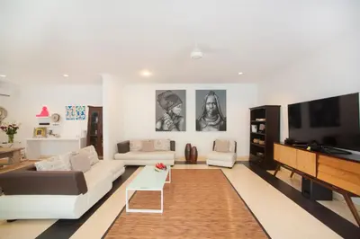 a living room with a couch and a flat screen tv at Villa Penelopy in Seminyak