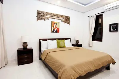 a bedroom with a bed in a white room at Villa Penelopy in Seminyak