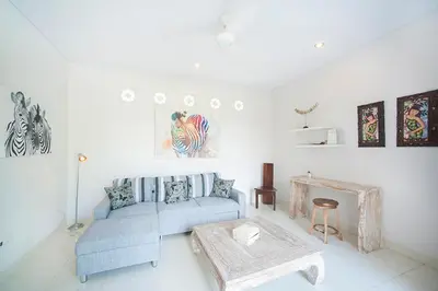 a living room with a blue couch and a table at Villa Penelopy in Seminyak