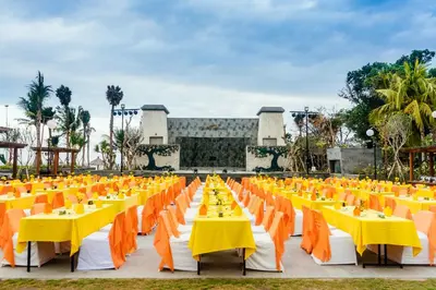 a row of tables with yellow and orange chairs at Grand Mirage Resort & Thalasso Bali - All Inclusive in Nusa Dua