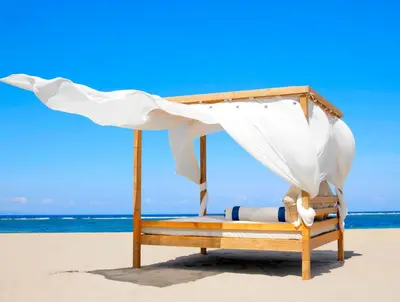 a bed with a canopy on the beach at Grand Mirage Resort & Thalasso Bali - All Inclusive in Nusa Dua