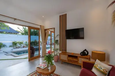 a living room with a tv and a couch and a table at Cosy 2bd Chic Villa with Private Pool in Central Location in Kerobokan