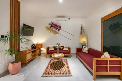 a living room with a red couch and a table at Cosy 2bd Chic Villa with Private Pool in Central Location in Kerobokan