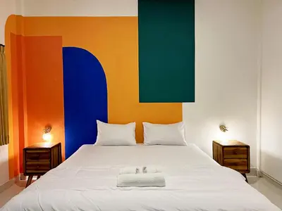 a bedroom with a large bed with a colorful headboard at Villaok in Kuta