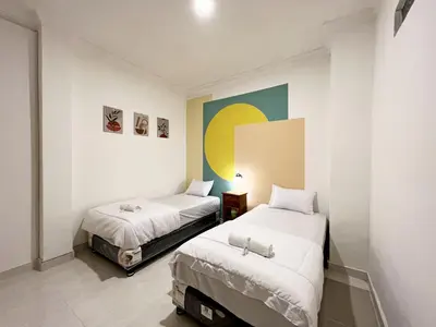 a room with two beds and a painting on the wall at Villaok in Kuta