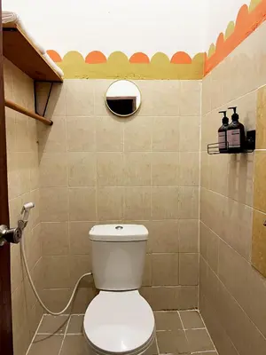 a bathroom with a white toilet in a room at Villaok in Kuta