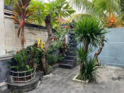 a garden with palm trees and plants in a building at Villaok in Kuta