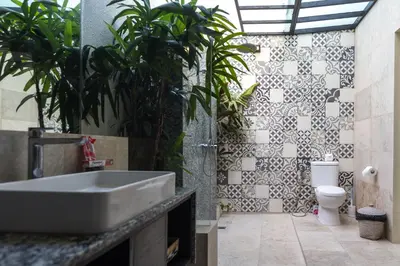 a bathroom with a sink and a toilet with plants at Villa Cantik in Canggu