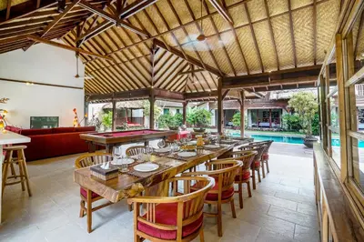 a restaurant with a long wooden table and chairs at Villa Cira - 5 Bedrooms Private Villa Next to Seminyak in Seminyak