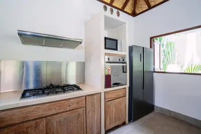 a kitchen with a stove and a refrigerator at Villa Cira - 5 Bedrooms Private Villa Next to Seminyak in Seminyak