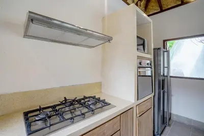 a kitchen with a stove and a refrigerator at Villa Cira - 5 Bedrooms Private Villa Next to Seminyak in Seminyak