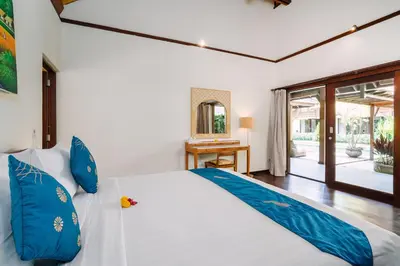 a bedroom with a large bed with blue pillows at Villa Cira - 5 Bedrooms Private Villa Next to Seminyak in Seminyak