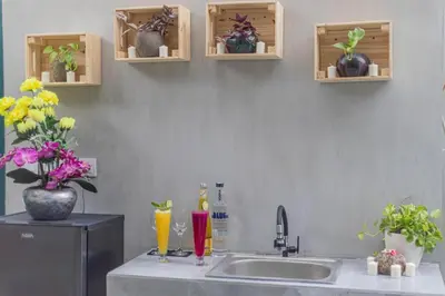 a kitchen with a sink and some bottles and flowers at Mezzanine Industrial 1 Bedroom Private Villa in Seminyak in Seminyak