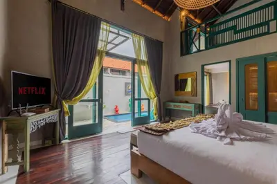 a bedroom with a bed and a large window at Mezzanine Industrial 1 Bedroom Private Villa in Seminyak in Seminyak