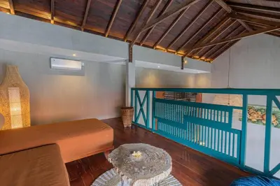 a living room with a bench and a table at Mezzanine Industrial 1 Bedroom Private Villa in Seminyak in Seminyak