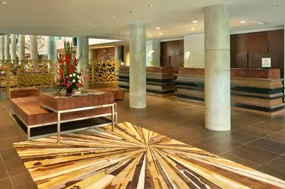 a lobby with columns and a floor with a star pattern at Hilton Garden Inn Bali Ngurah Rai Airport in Kuta