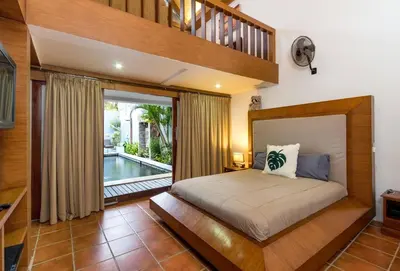 a bedroom with a bed and a balcony at Buddha Beach Villa Seminyak in Seminyak