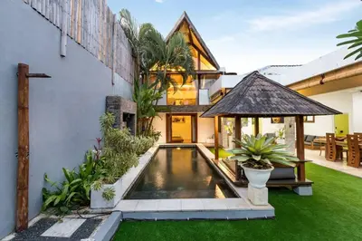 a house with a swimming pool in the yard at Buddha Beach Villa Seminyak in Seminyak