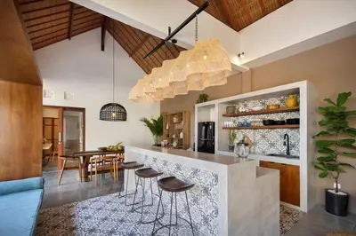 a kitchen with a bar with stools at Villa Pawikan Gorgeous 4 beds villa in the heart of Seminyak in Seminyak