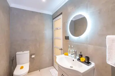 a bathroom with a toilet and a sink and a mirror at Central 3bd Modern Villa with Private Pool and Play Area in Kerobokan
