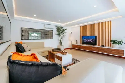 a living room with a couch and a tv at Spacious 4 Bedroom Private Villa in buzzy of Seminyak in Canggu