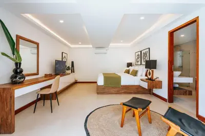 a bedroom with a bed and a desk and a mirror at Spacious 4 Bedroom Private Villa in buzzy of Seminyak in Canggu
