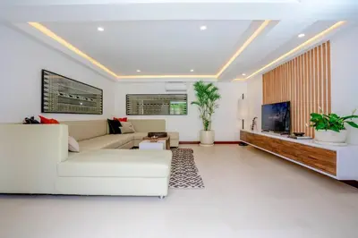 a living room with a white couch and a tv at Spacious 4 Bedroom Private Villa in buzzy of Seminyak in Canggu