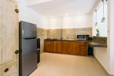 a kitchen with a stainless steel refrigerator and wooden cabinets at Private villa with pool near 66 in Seminyak in Seminyak