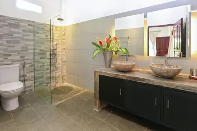 two sinks in a bathroom with a toilet and a shower at Private villa with pool near 66 in Seminyak in Seminyak