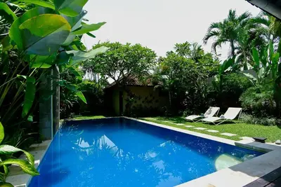 a swimming pool in a yard with two chairs at Private villa with pool near 66 in Seminyak in Seminyak