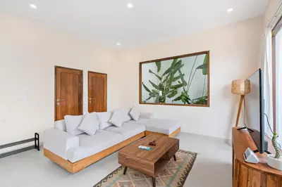 a living room with a white couch and a table at Roselle Villa by Betterplace in Canggu