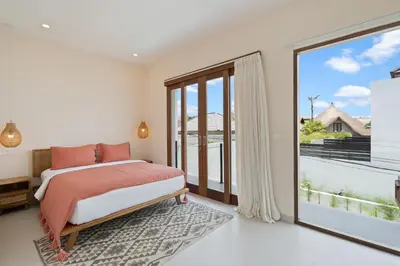 a bedroom with a bed and a large window at Roselle Villa by Betterplace in Canggu