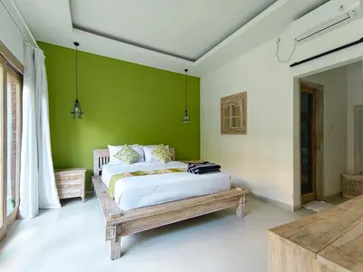 a bedroom with two beds and a green wall at New Villa Lotus 2BR Private Pool Villas in Seminyak