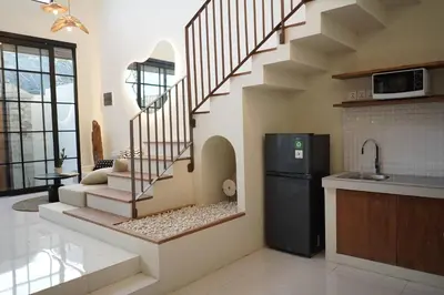 a kitchen with a spiral staircase in a house at VILLA HAWILA 2BR OBEROI SEMINYAK PRIME LOCATION - No FLOOD in Seminyak