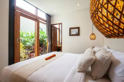 a bedroom with a white bed with a large window at Luxury 3bd Villa 5 Min From Berawa Beach in Canggu